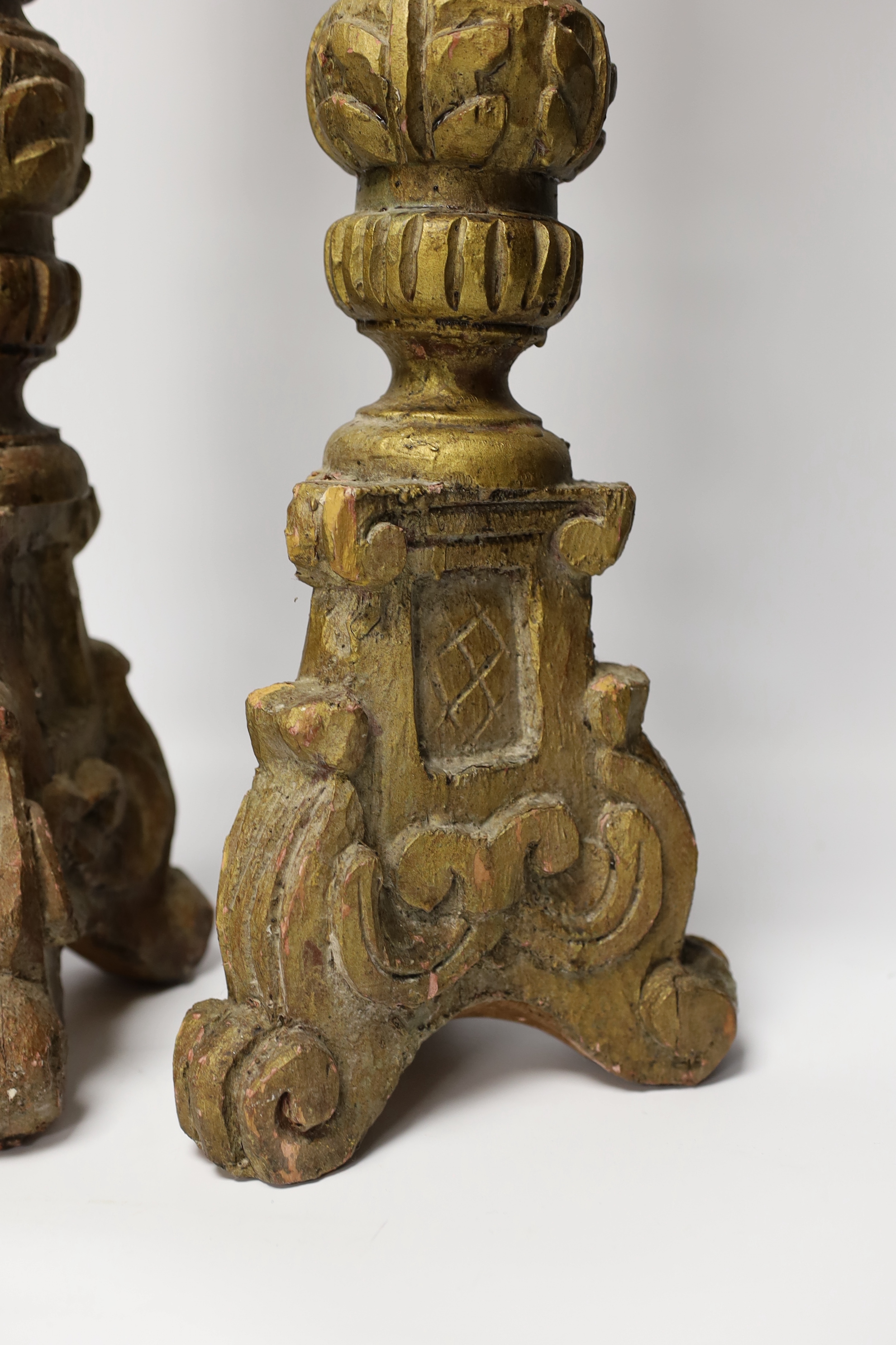A pair of gilt and carved wooden altar sticks, 71cm